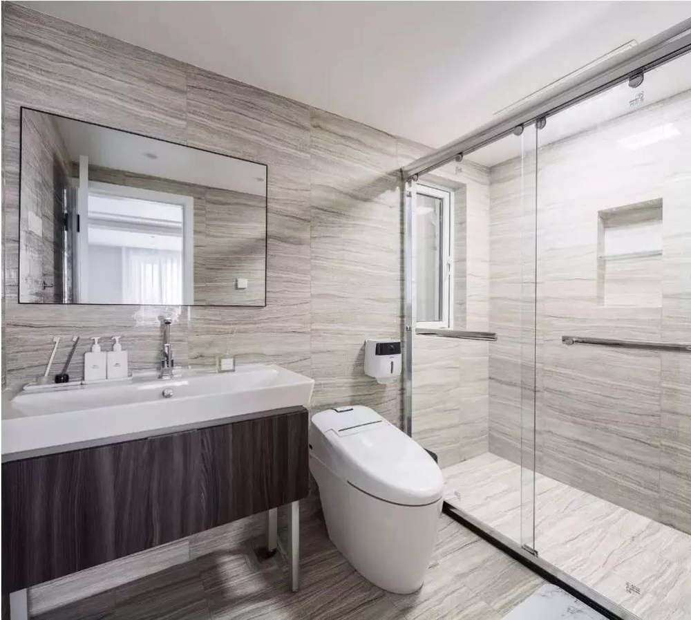 卫生间整体通铺石色纹理瓷砖,利用墙面在淋浴房内设计壁龛,可放置